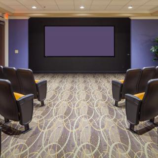 A cozy home theater setup with comfortable seating and a large projector screen.