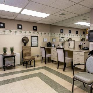 A well-organized salon interior featuring chairs, mirrors, and hair dryers with a cozy waiting area and decorative wall art.