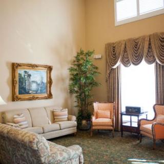 A cozy and elegantly decorated living room with plush furniture and framed artwork.
