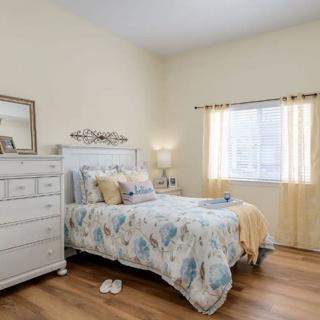 A cozy bedroom with a neatly made bed and a window allowing natural light.