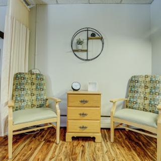A cozy seating area featuring two patterned chairs and a small wooden table between them.