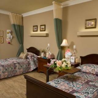 A cozy bedroom with twin floral-patterned beds and traditional decor.