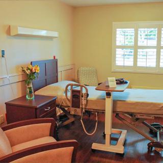 A well-equipped, clean hospital room with a patient bed and medical equipment.