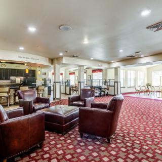 A spacious lobby with comfortable leather seating and a patterned carpet.