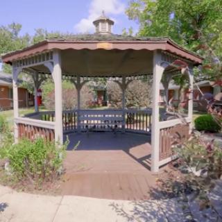 A beautifully designed gazebo in a serene garden setting.
