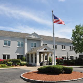 A well-maintained building featuring an American flag in a landscaped environment.