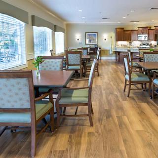 Bright and spacious dining area with wooden flooring and elegant furniture.