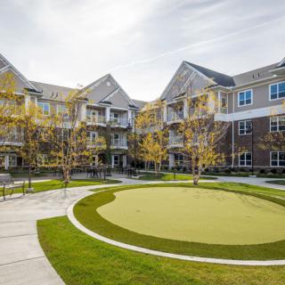 A view of a modern residential apartment complex with landscaped surroundings and green spaces.