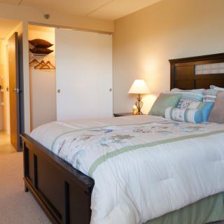 A cozy bedroom with a comfortable bed and a small lamp lighting the room.