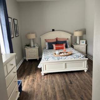 A cozy and well-decorated bedroom featuring a comfortable bed, stylish nightstands, and warm lighting.