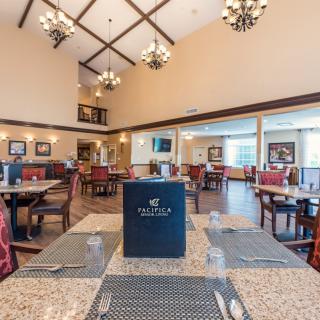 A spacious and elegantly decorated restaurant dining area with neatly arranged tables.