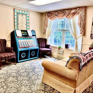A cozy living room featuring a jukebox and classic furnishings.