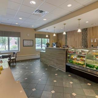 A modern cafe interior with a display case and seating area.
