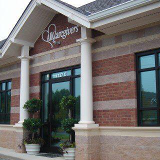 An elegant brick building featuring large windows and decorative columns.
