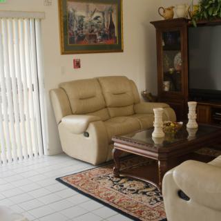 A cozy living room with a beige sofa, wooden coffee table, and a large television.