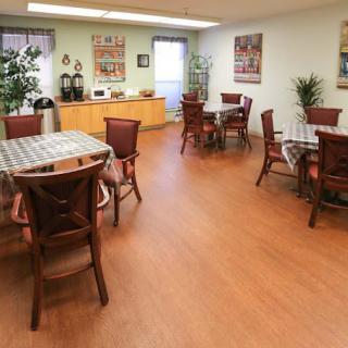 A spacious dining area with multiple tables and chairs, adorned with plants and wall decorations.