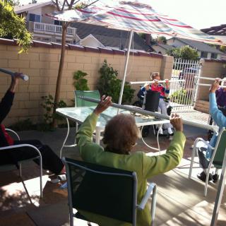 A group of people enjoying a sunny day on the patio.