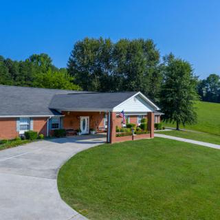A beautiful home surrounded by lush greenery and clear blue skies.