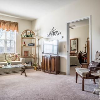 A cozy living room with a television, a comfortable sofa, and well-arranged decorations.