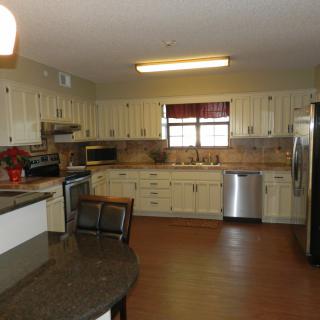 A spacious kitchen with cream-colored cabinets and modern appliances.