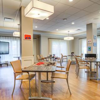 A modern dining area with tables, chairs, and contemporary lighting.