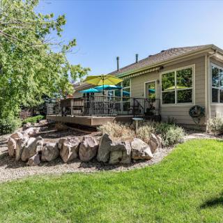 A beautiful backyard featuring a spacious deck and lush green lawn, perfect for outdoor gatherings.