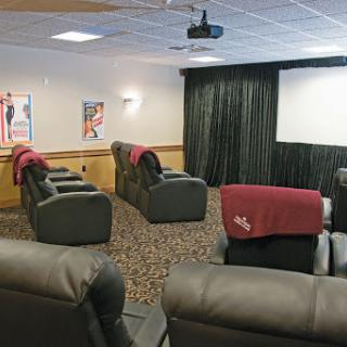 A cozy home theater setup featuring recliner chairs and a projection screen, perfect for movie nights.