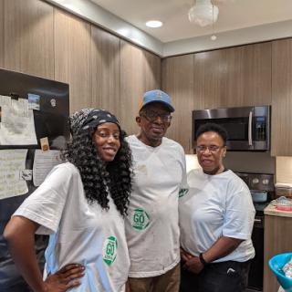 A cheerful group of three individuals posing together in a modern kitchen.
