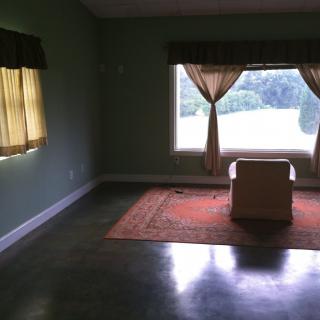 A minimalist room with a single chair in front of a window.
