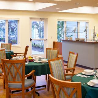 A cozy dining room with neatly set tables and comfortable chairs.