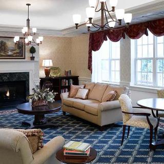 A cozy living room with elegant furnishings, including a sofa, coffee table, and fireplace.