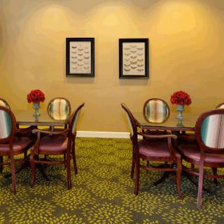 A well-decorated dining area with tables, chairs, and floral arrangements.