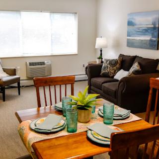 A cozy living room and dining area, featuring a well-set table and inviting seating.