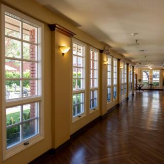 A well-lit hallway with large windows and a wooden floor.