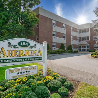 Entrance of Aberjona, a residential apartment complex surrounded by well-maintained landscaping.
