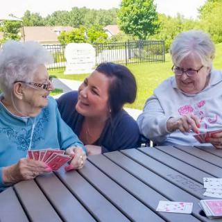 A group of friends enjoying a game of cards outside, sharing laughter and smiles.