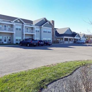 A residential building with a parking lot and cars on a clear day.