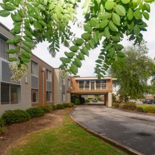A modern building with a sky bridge surrounded by lush greenery.