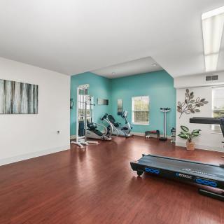 A modern gym with exercise equipment and a treadmill in a spacious room.