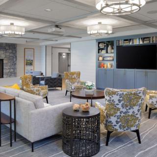 A modern living room with comfortable seating, elegant lighting, and a large television.