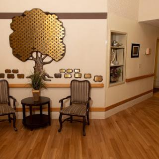 A welcoming waiting area featuring stylish chairs, a small table, and decorative wall art.