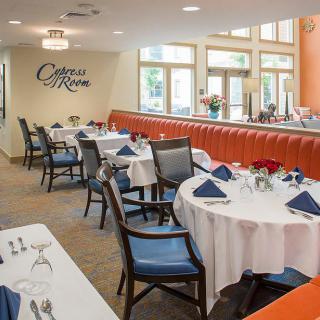 An elegant restaurant dining room with neatly set tables and comfortable chairs.