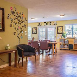 A cozy dining area featuring a wooden floor, decorated walls, and comfortable seating.
