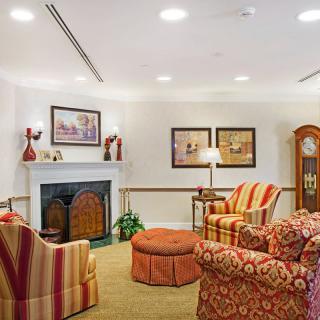 A cozy living room with a traditional design, featuring comfortable armchairs and a fireplace.