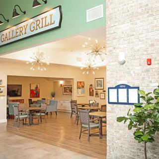 An indoor view of a restaurant's dining area featuring tables, chairs, and decorative lighting.