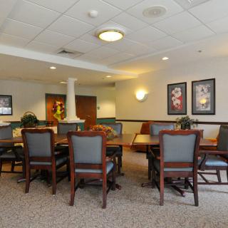 A cozy dining area with tables and chairs, decorated with wall art and ambient lighting.