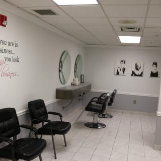 A modern salon waiting area with chairs, mirrors, and stylish decor.