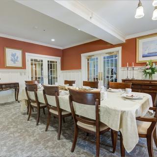 An elegant dining room with a long table set for a formal meal.