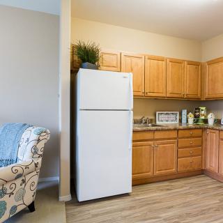 A cozy kitchen with wooden cabinets and a white refrigerator.