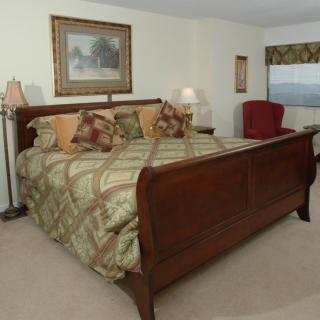 A cozy bedroom with a large wooden bed and elegant decor.